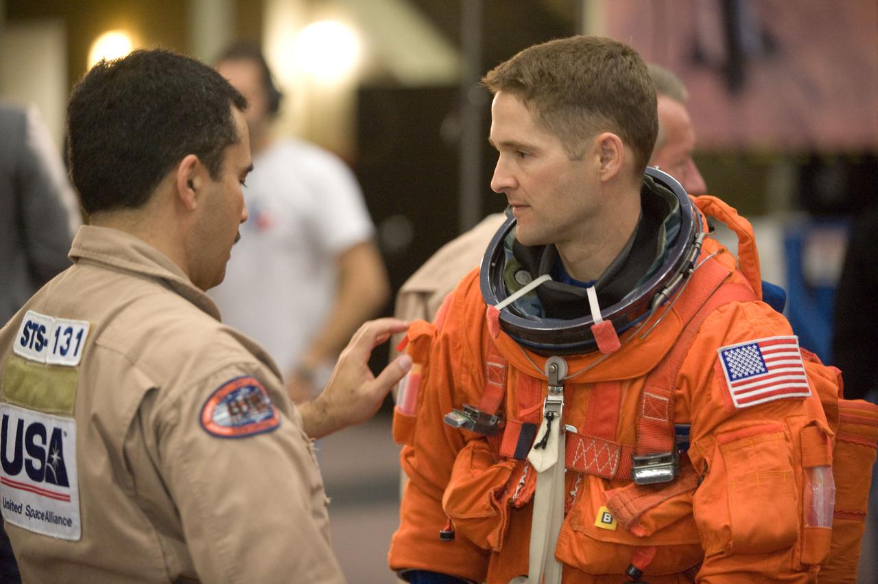 JSC2010-E-017731 (29 Jan. 2010) --- NASA astronaut James P. Dutton Jr., STS-131 pilot, attired in a training version of his shuttle launch and entry suit, prepares for an ingress/egress training session in the Space Vehicle Mock-up Facility at NASA's Johnson Space Center. United Space Alliance suit technician Raymond Cuevas assisted Dutton.