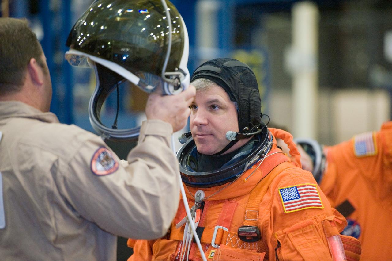 JSC2010-E-018527 (3 Feb. 2010) --- NASA astronaut Gregory H. Johnson, STS-134 pilot, gets help with the donning of a training version of his shuttle launch and entry suit in preparation for a training session in the Space Vehicle Mock-up Facility at NASA's Johnson Space Center.
