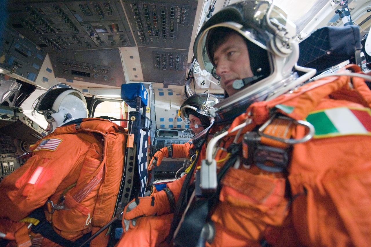 JSC2010-E-018554 (3 Feb. 2010) --- Attired in training versions of their shuttle launch and entry suits, NASA astronauts Gregory H. Johnson (left), STS-134 pilot; and Michael Fincke (right background), mission specialist; along with European Space Agency astronaut Roberto Vittori, mission specialist, participate in a training session on the flight deck of the Full Fuselage Trainer (FFT) in the Space Vehicle Mock-up Facility at NASA's Johnson Space Center.