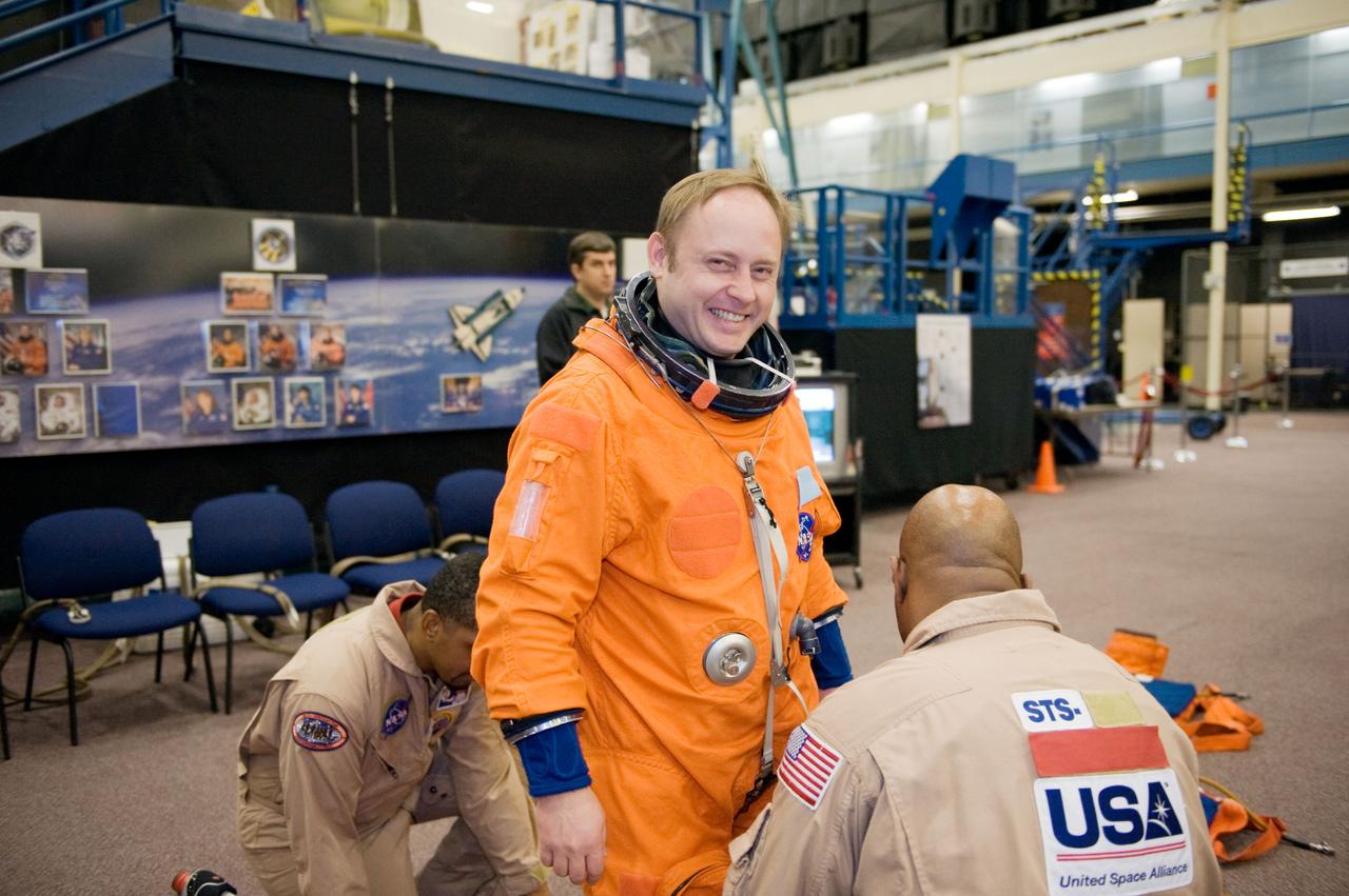JSC2010-E-018582 (3 Feb. 2010) --- NASA astronaut Michael Fincke, STS-134 mission specialist, gets help with the donning of a training version of his shuttle launch and entry suit in preparation for a training session in the Space Vehicle Mock-up Facility at NASA?s Johnson Space Center.