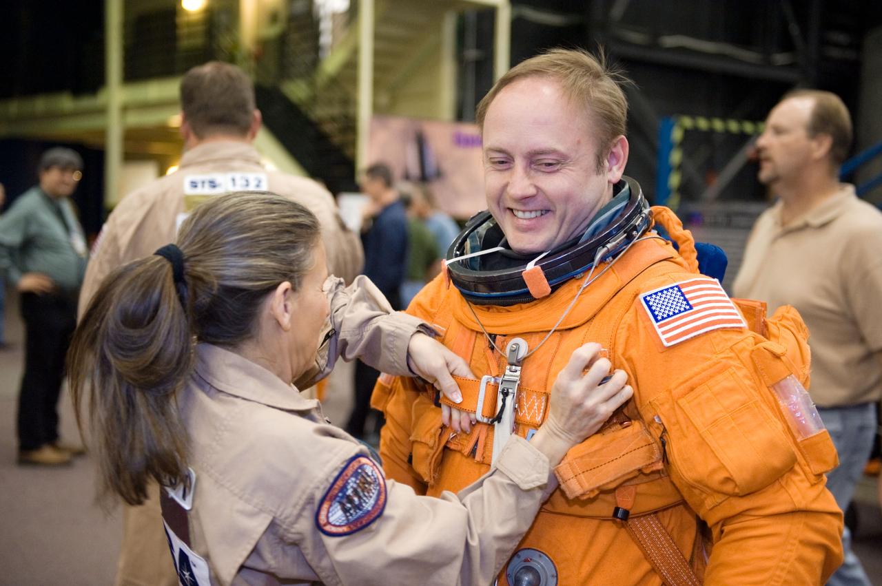 JSC2010-E-018584 (3 Feb. 2010) --- NASA astronaut Michael Fincke, STS-134 mission specialist, dons a training version of his shuttle launch and entry suit in preparation for a training session in the Space Vehicle Mock-up Facility at NASA?s Johnson Space Center. United Space Alliance suit technician Toni Cost-Davis assisted Fincke.