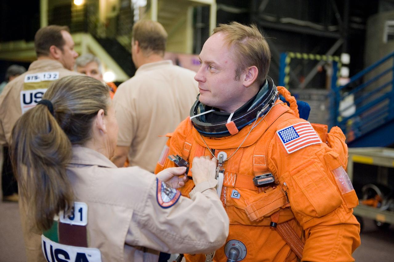 JSC2010-E-018585 (3 Feb. 2010) --- NASA astronaut Michael Fincke, STS-134 mission specialist, dons a training version of his shuttle launch and entry suit in preparation for a training session in the Space Vehicle Mock-up Facility at NASA?s Johnson Space Center. United Space Alliance suit technician Toni Cost-Davis assisted Fincke.