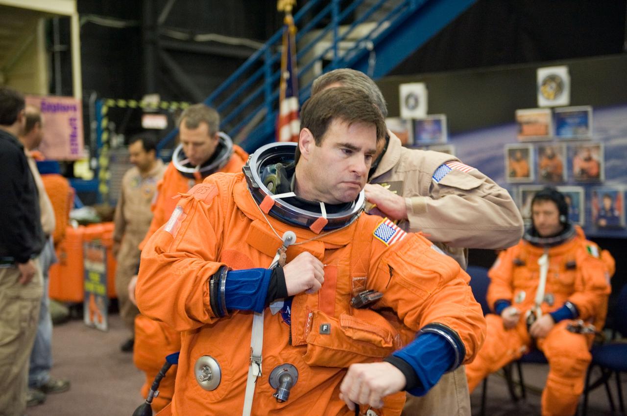 JSC2010-E-018590 (3 Feb. 2010) --- NASA astronaut Greg Chamitoff, STS-134 mission specialist, gets help with the donning of a training version of his shuttle launch and entry suit in preparation for a training session in the Space Vehicle Mock-up Facility at NASA?s Johnson Space Center.