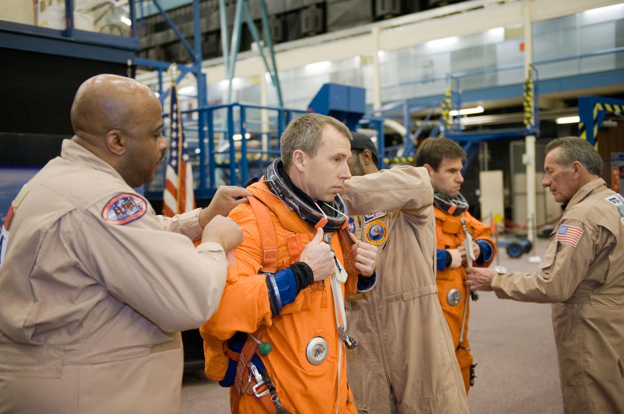 JSC2010-E-018594 (3 Feb. 2010) --- NASA astronaut Andrew Feustel, STS-134 mission specialist, gets help with the donning of a training version of his shuttle launch and entry suit in preparation for a training session in the Space Vehicle Mock-up Facility at NASA?s Johnson Space Center.