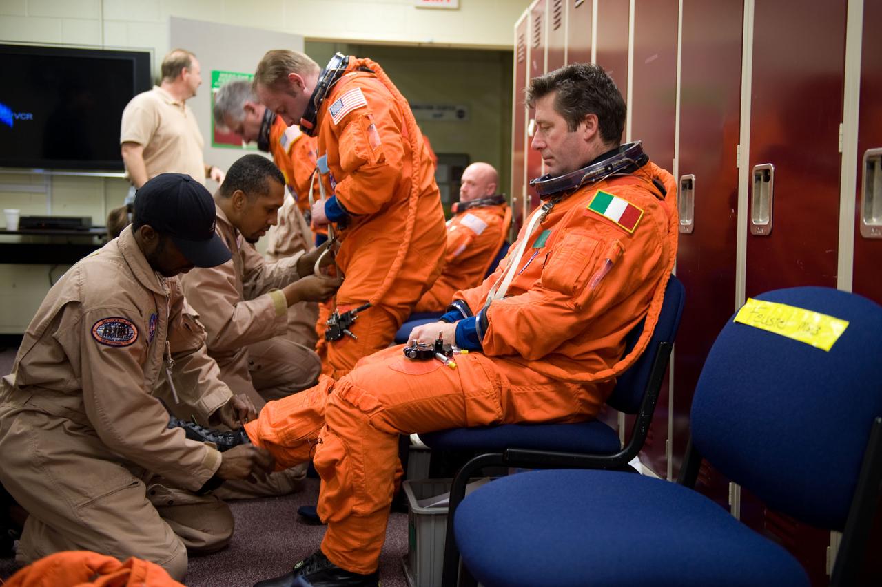 JSC2010-E-018871 (3 Feb. 2010) --- European Space Agency astronaut Roberto Vittori, STS-134 mission specialist, gets help with the donning of a training version of his shuttle launch and entry suit in preparation for a training session in the Space Vehicle Mock-up Facility at NASA?s Johnson Space Center.