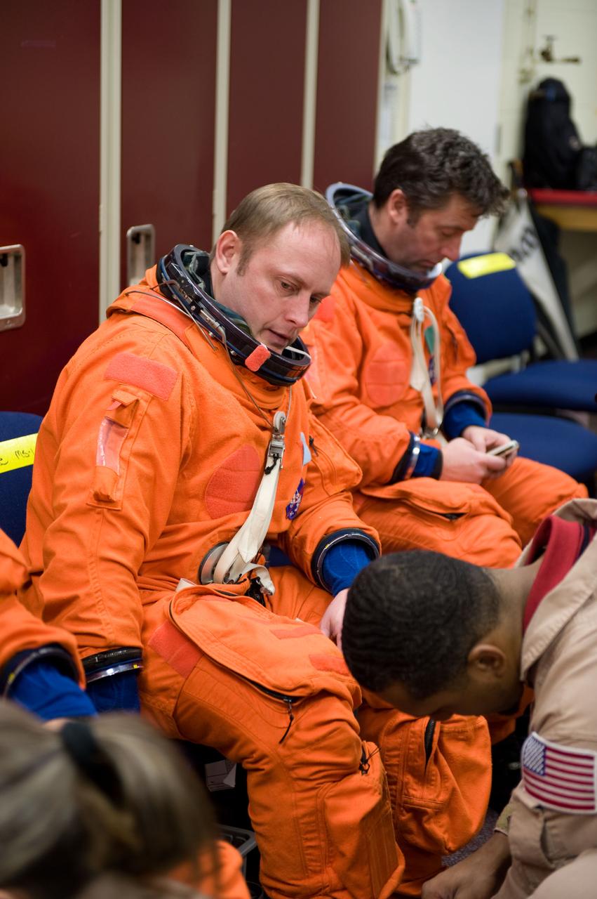 JSC2010-E-018873 (3 Feb. 2010) --- NASA astronaut Michael Fincke, STS-134 mission specialist, gets help with the donning of a training version of his shuttle launch and entry suit in preparation for a training session in the Space Vehicle Mock-up Facility at NASA?s Johnson Space Center. European Space Agency astronaut Roberto Vittori, mission specialist, is visible in the background.