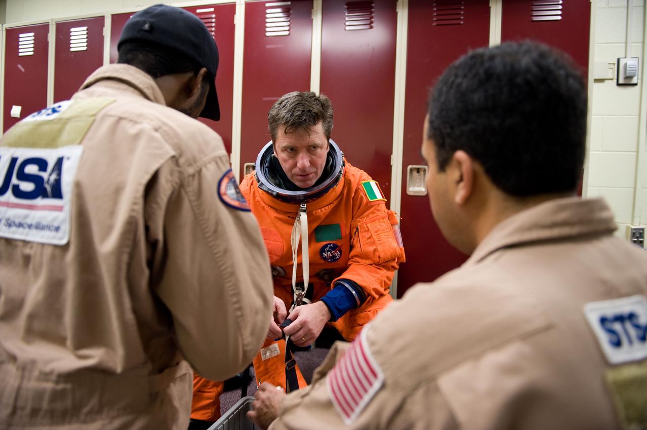 JSC2010-E-018878 (3 Feb. 2010) --- European Space Agency astronaut Roberto Vittori, STS-134 mission specialist, gets help with the donning of a training version of his shuttle launch and entry suit in preparation for a training session in the Space Vehicle Mock-up Facility at NASA?s Johnson Space Center.