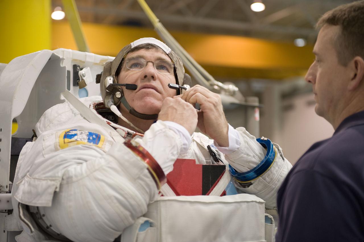 JSC2010-E-019608 (8 Feb. 2010) --- NASA astronaut Steve Bowen, STS-132 mission specialist, dons a training version of his Extravehicular Mobility Unit (EMU) spacesuit in preparation for a spacewalk training session in the waters of the Neutral Buoyancy Laboratory (NBL) near NASA's Johnson Space Center. Astronaut Ken Ham, commander, assisted Bowen.
