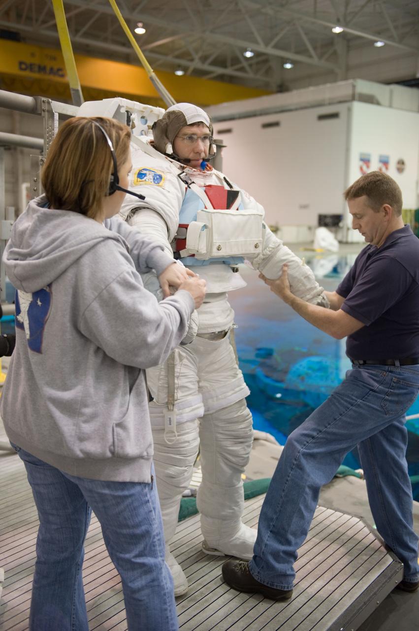 JSC2010-E-019610 (8 Feb. 2010) --- NASA astronaut Steve Bowen, STS-132 mission specialist, gets help in the donning of a training version of his Extravehicular Mobility Unit (EMU) spacesuit in preparation for a spacewalk training session in the waters of the Neutral Buoyancy Laboratory (NBL) near NASA's Johnson Space Center. Astronaut Ken Ham, commander, is at right.
