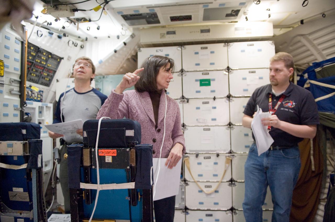 JSC2010-E-023632 (4 Feb. 2010) --- NASA astronauts Michael Barratt (left) and Nicole Stott, both STS-133 mission specialists, participate in training session in a shuttle mock-up in the Space Vehicle Mock-up Facility at NASA's Johnson Space Center. United Space Alliance instructor James Gaustad assisted Barratt and Stott.