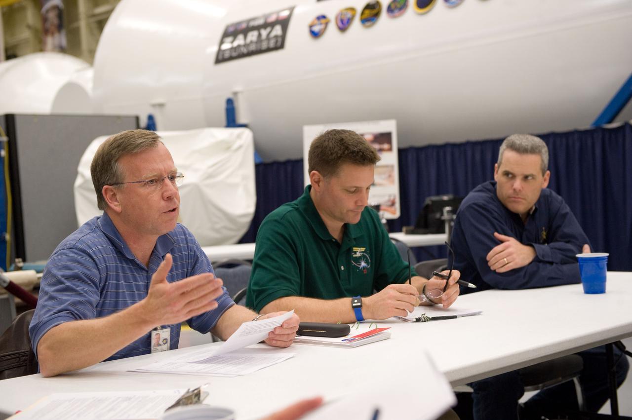 JSC2010-E-024372 (18 Feb. 2010) --- NASA astronauts Steve Lindsey (left), STS-133 commander; and Doug Wheelock, Expedition 24 flight engineer and Expedition 25 commander, participate in a training session in the Space Vehicle Mock-up Facility at NASA's Johnson Space Center. Flight director Brian T. Smith is at right.