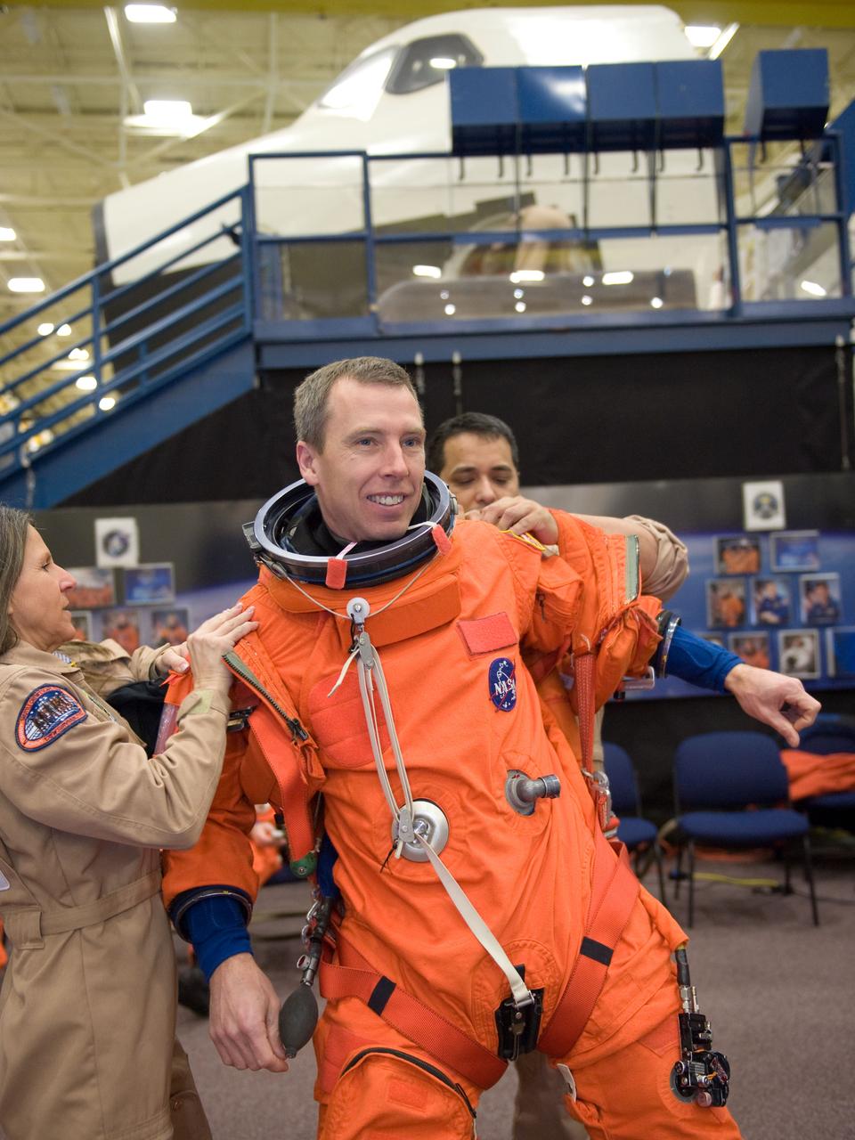 JSC2010-E-024588 (11 Feb. 2010) --- NASA astronaut Andrew Feustel, STS-134 mission specialist, gets help with the donning of a training version of his shuttle launch and entry suit in preparation for a training session in the Space Vehicle Mock-up Facility at NASA?s Johnson Space Center.