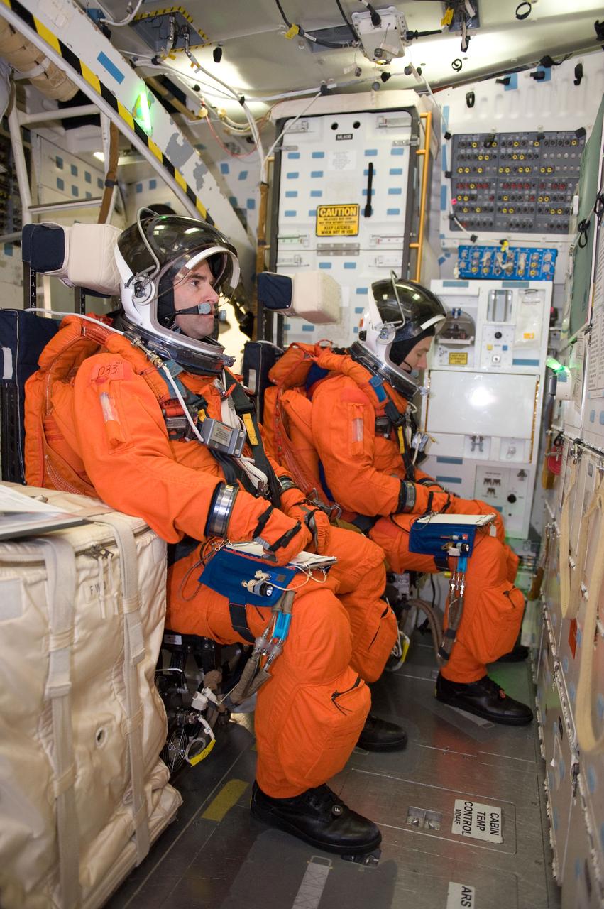 JSC2010-E-024595 (11 Feb. 2010) --- Attired in training versions of their shuttle launch and entry suits, NASA astronauts Greg Chamitoff (foreground) and Andrew Feustel, both STS-134 mission specialists, participate in a training session on the middeck of the crew compartment trainer (CCT-2) in the Space Vehicle Mockup Facility at NASA's Johnson Space Center.