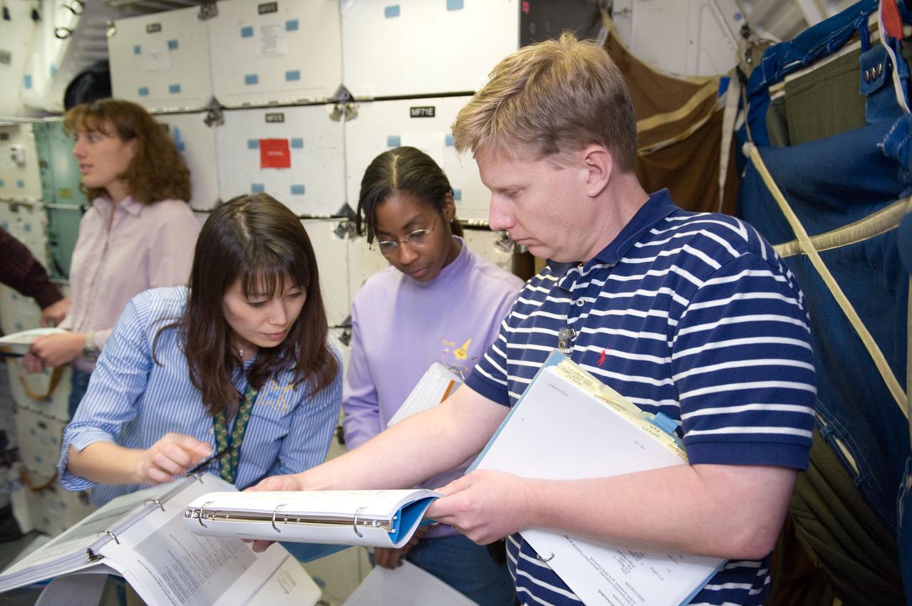 JSC2010-E-024625 (10 Feb. 2010) --- Japan Aerospace Exploration Agency (JAXA) astronaut Naoko Yamazaki (center) along with NASA astronauts Dorothy Metcalf-Lindenburger (background) and Stephanie Wilson, all STS-131 mission specialists, participate in an ingress/egress timeline training session in a shuttle mock-up in the Space Vehicle Mock-up Facility at NASA's Johnson Space Center. United Space Alliance (USA) instructor Gary W. Kilgo assisted the crew members.