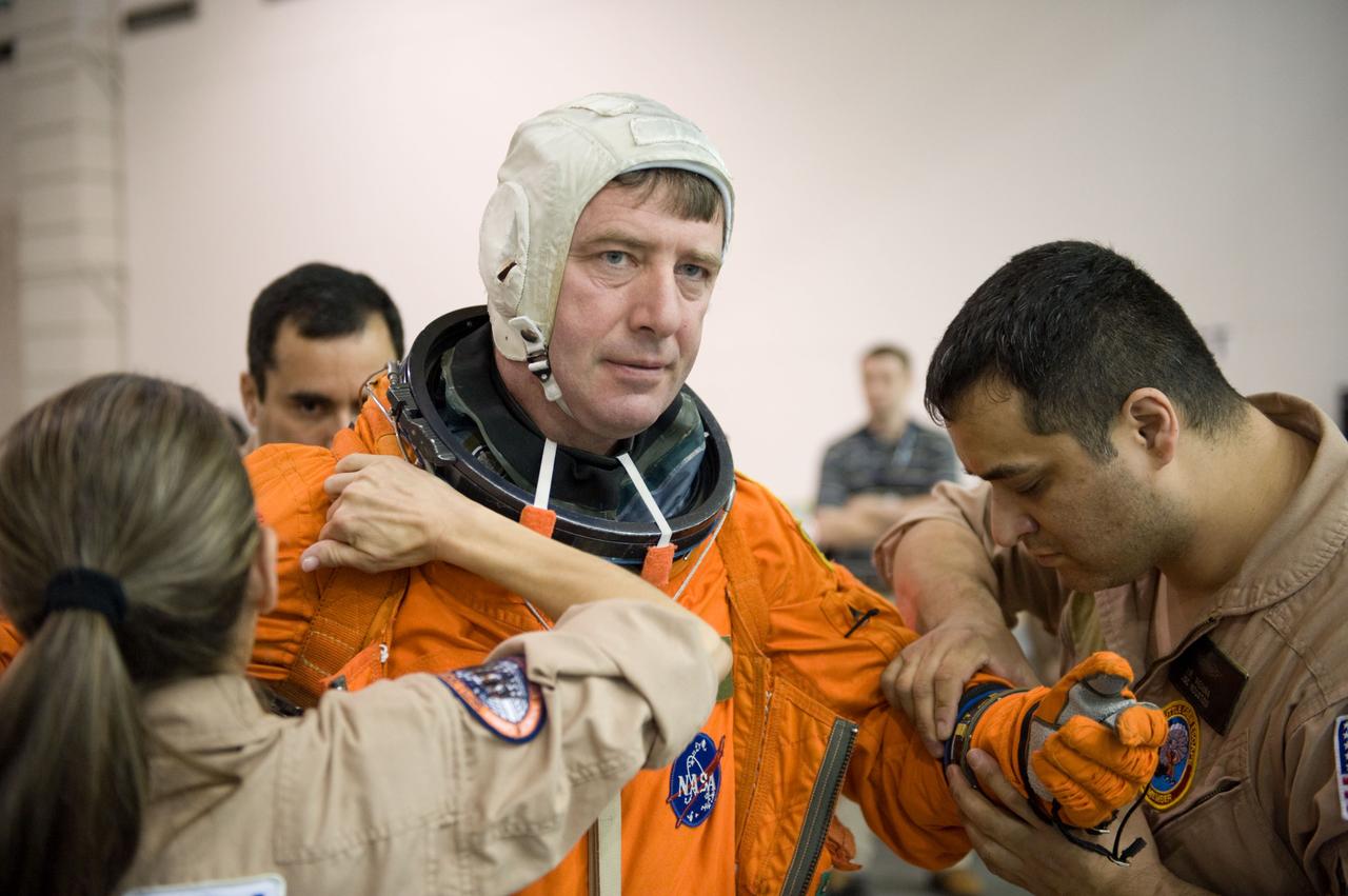 JSC2001-E-025694 (23 Feb. 2010) --- European Space Agency astronaut Roberto Vittori, STS-134 mission specialist, gets helps with the donning of a training version of his shuttle launch and entry suit in preparation for a water survival training session in the Neutral Buoyancy Laboratory (NBL) near NASA's Johnson Space Center.