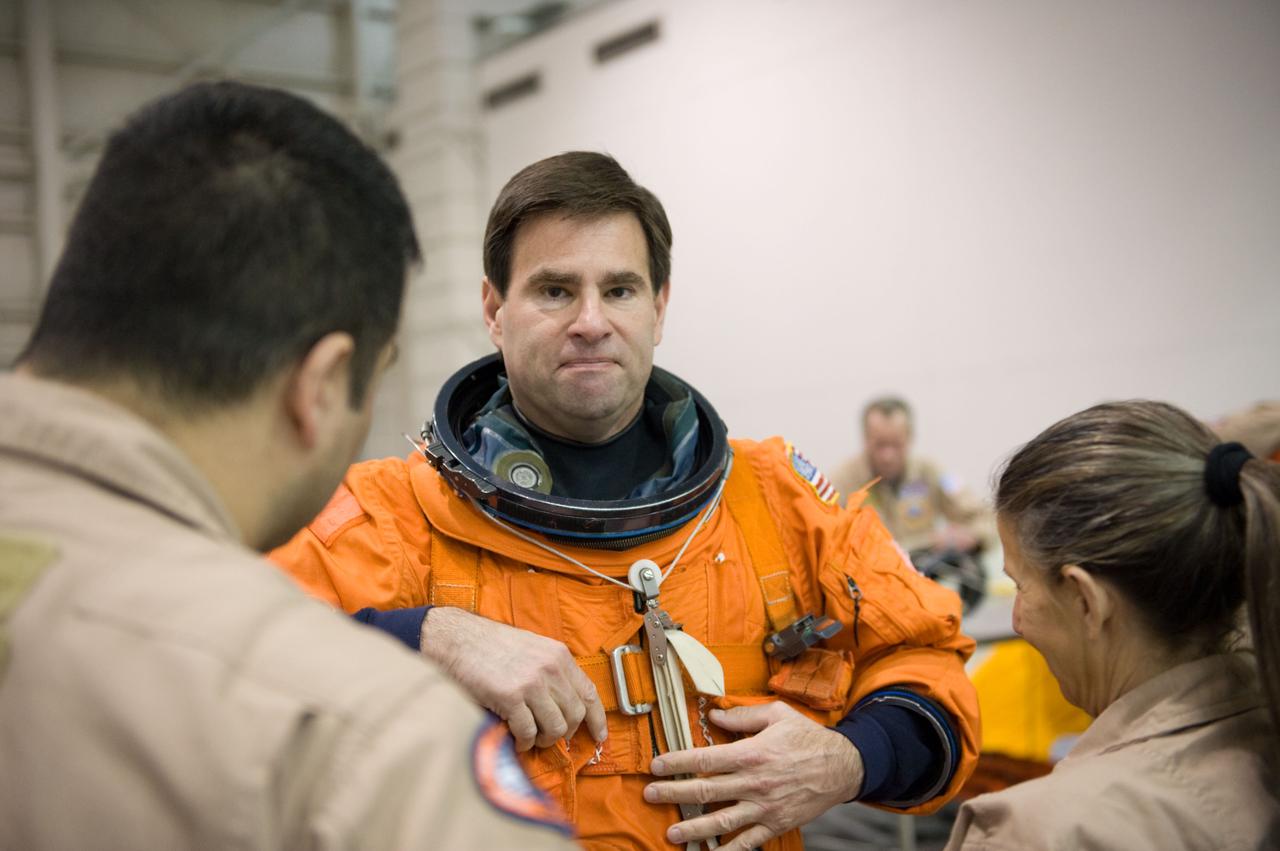 JSC2010-E-025724 (23 Feb. 2010) --- NASA astronaut Greg Chamitoff, STS-134 mission specialist, gets helps with the donning of a training version of his shuttle launch and entry suit in preparation for a water survival training session in the Neutral Buoyancy Laboratory (NBL) near NASA's Johnson Space Center.