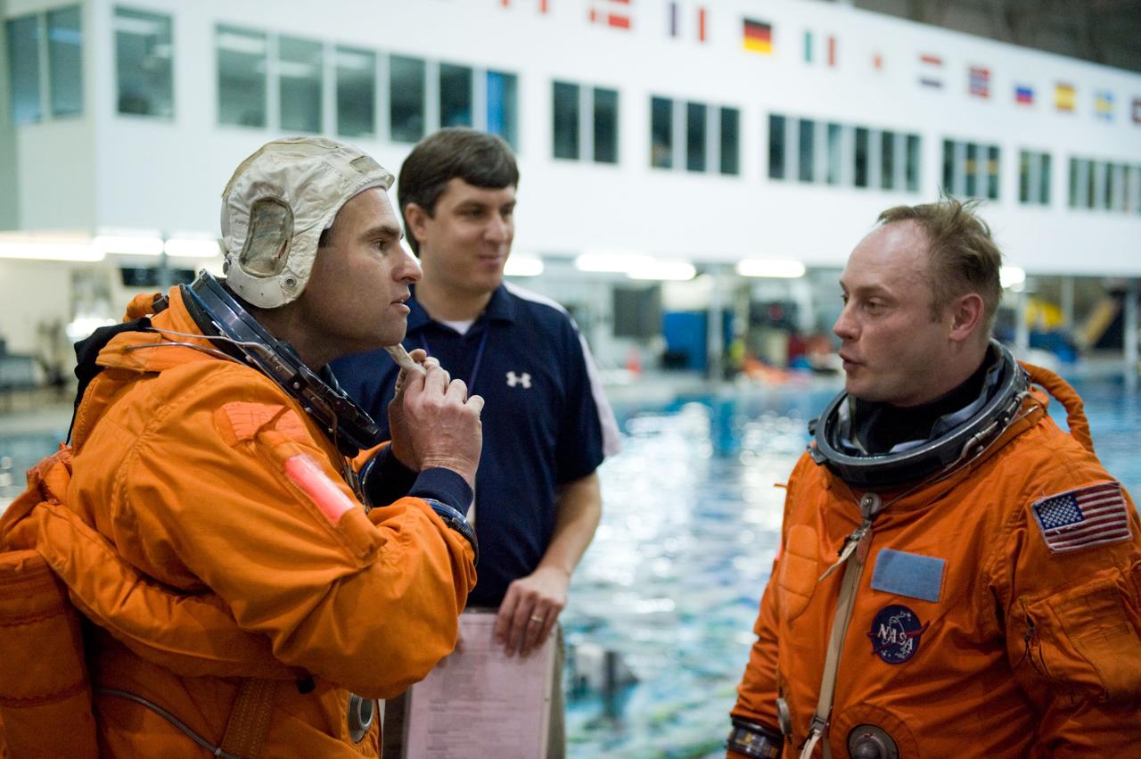 JSC2010-E-025725 (23 Feb. 2010) --- Attired in training versions of their shuttle launch and entry suits, NASA astronauts Greg Chamitoff (left) and Michael Fincke, both STS-134 mission specialists, participate in a water survival training session in the Neutral Buoyancy Laboratory (NBL) near NASA's Johnson Space Center.