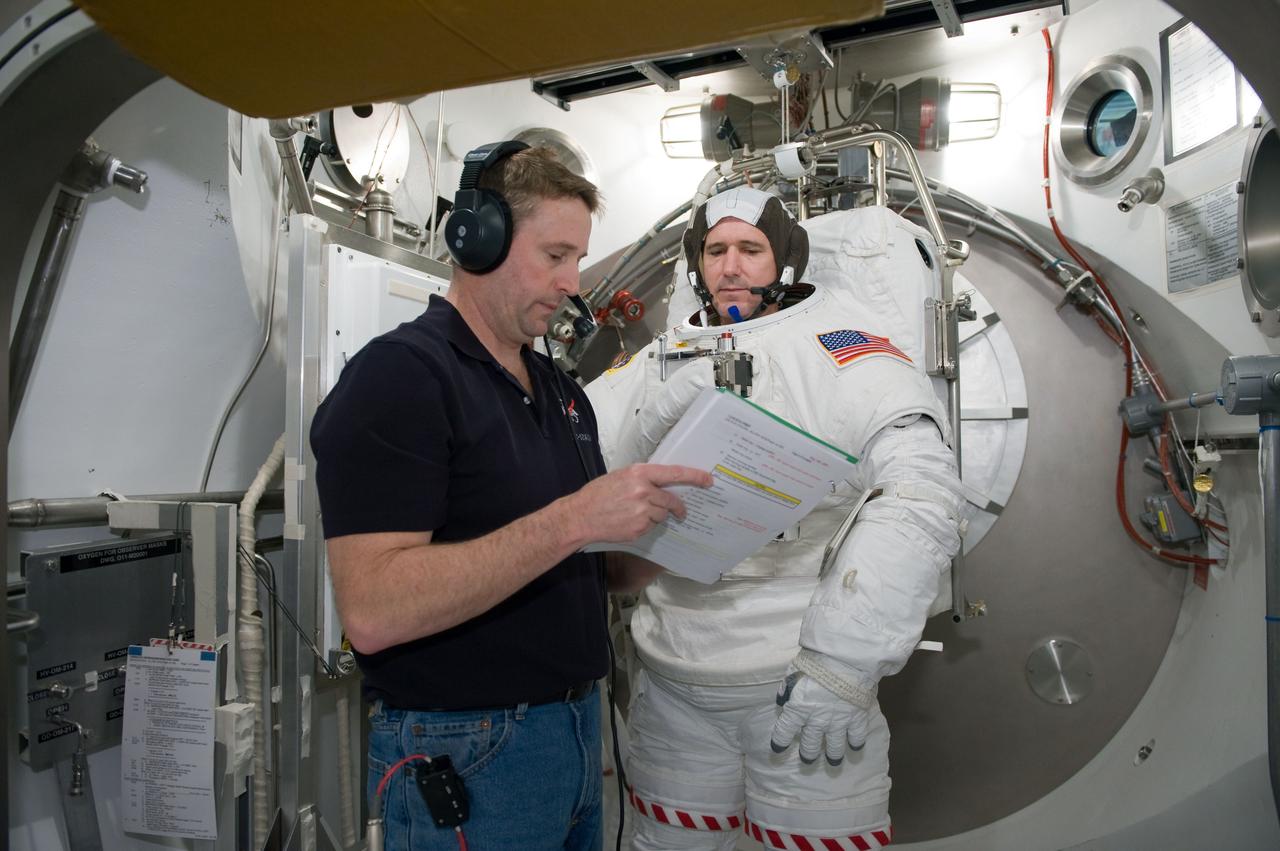 JSC2010-E-026890 (26 Feb. 2010) --- NASA astronaut Michael Good, STS-132 mission specialist, participates in an Extravehicular Mobility Unit (EMU) spacesuit fit check in the Space Station Airlock Test Article (SSATA) in the Crew Systems Laboratory at NASA's Johnson Space Center. Astronaut Ken Ham, commander, assisted Good.