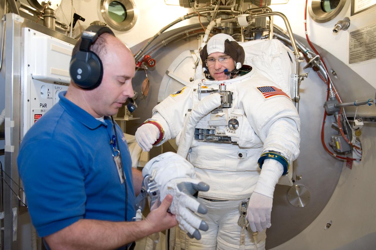 JSC2010-E-039451 (10 March 2010) --- NASA astronaut Steve Bowen, STS-132 mission specialist, participates in an Extravehicular Mobility Unit (EMU) spacesuit fit check in the Space Station Airlock Test Article (SSATA) in the Crew Systems Laboratory at NASA's Johnson Space Center. Astronaut Garrett Reisman, mission specialist, assisted Bowen.