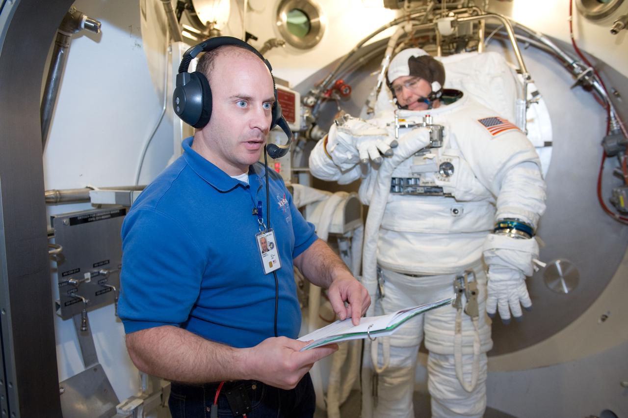JSC2010-E-039453 (10 March 2010) --- NASA astronaut Steve Bowen, STS-132 mission specialist, participates in an Extravehicular Mobility Unit (EMU) spacesuit fit check in the Space Station Airlock Test Article (SSATA) in the Crew Systems Laboratory at NASA's Johnson Space Center. Astronaut Garrett Reisman, mission specialist, assisted Bowen.
