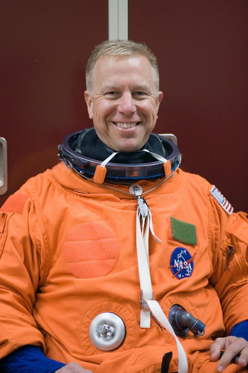 JSC2010-E-042070 (23 March 2010) --- NASA astronaut Tim Kopra, STS-133 mission specialist, attired in a training version of his shuttle launch and entry suit, awaits the start of a training session in the Space Vehicle Mock-up Facility at NASA's Johnson Space Center.