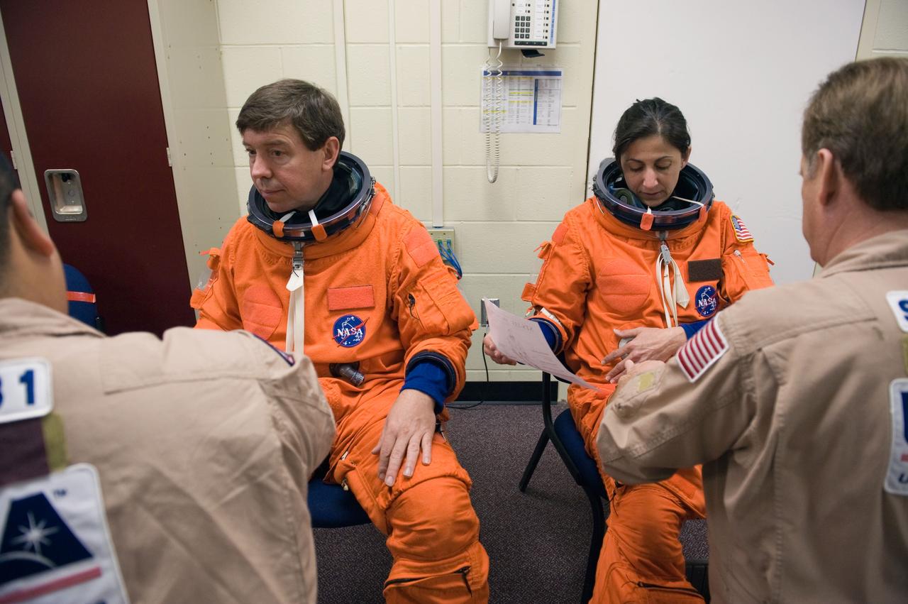 JSC2010-E-042079 (23 March 2010) --- NASA astronauts Michael Barratt and Nicole Stott, both STS-133 mission specialists, attired in training versions of their shuttle launch and entry suits, prepare for a training session in the Space Vehicle Mock-up Facility at NASA's Johnson Space Center. United Space Alliance suit technicians assisted Barratt and Stott.