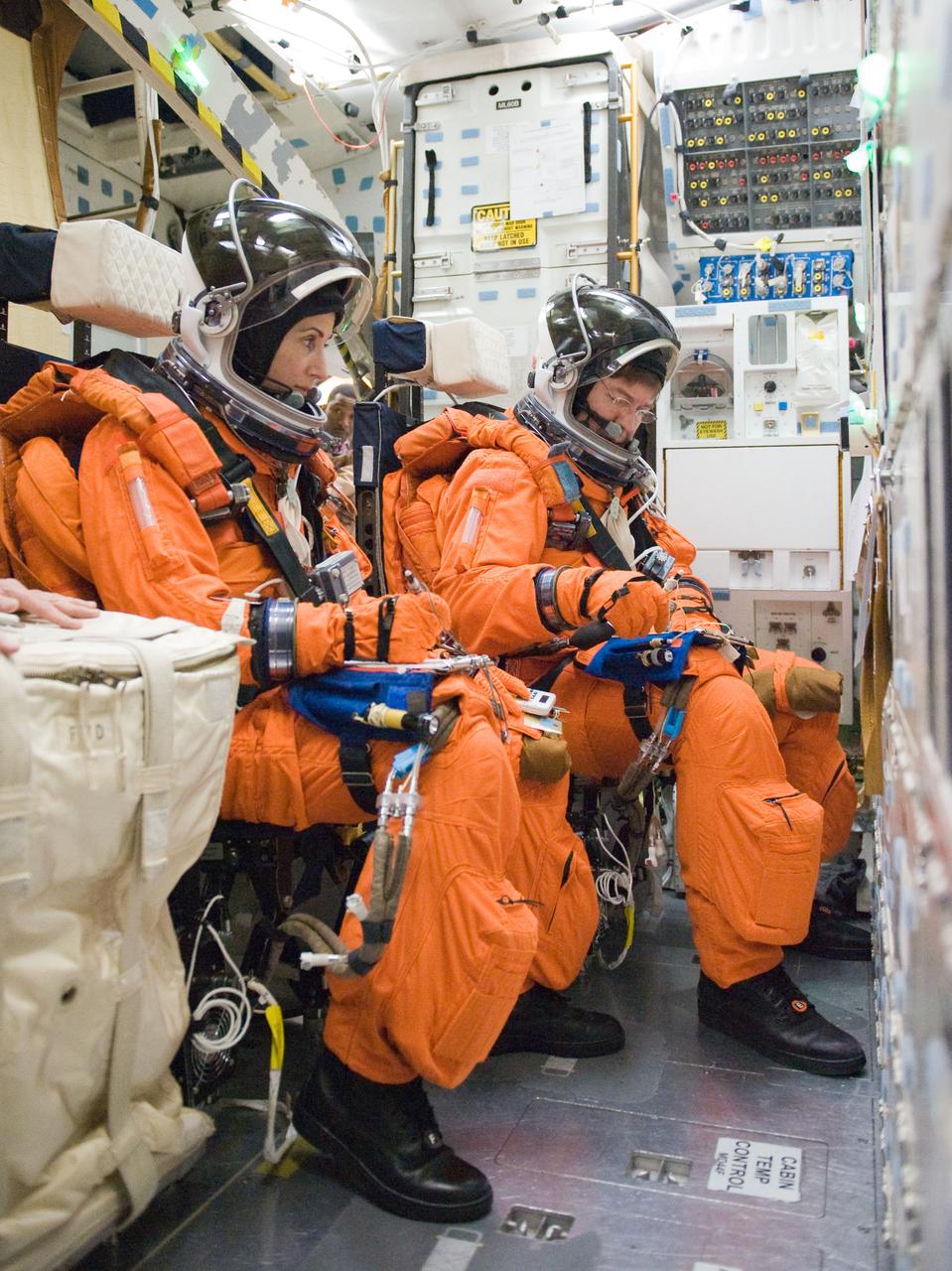JSC2010-E-042086 (23 March 2010) --- NASA astronauts Nicole Stott and Michael Barratt, both STS-133 mission specialists, participate in a post insertion/de-orbit training session on the middeck of the crew compartment trainer (CCT-2) in the Space Vehicle Mockup Facility at NASA's Johnson Space Center. Stott and Barratt are wearing training versions of their shuttle launch and entry suits.
