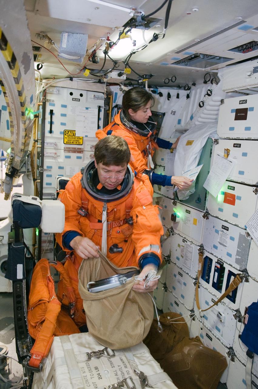 JSC2010-E-042090 (23 March 2010) --- NASA astronauts Nicole Stott and Michael Barratt, both STS-133 mission specialists, participate in a post insertion/de-orbit training session on the middeck of the crew compartment trainer (CCT-2) in the Space Vehicle Mockup Facility at NASA's Johnson Space Center. Stott and Barratt are wearing training versions of their shuttle launch and entry suits.