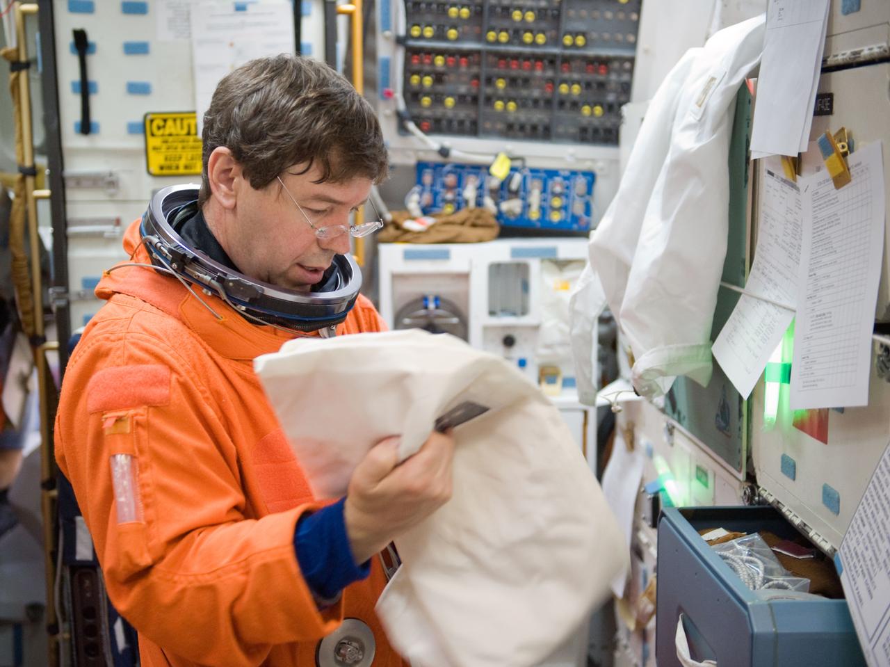 JSC2010-E-042093 (23 March 2010) --- Attired in a training version of his shuttle launch and entry suit, NASA astronaut Michael Barratt, STS-133 mission specialist, participates in a post insertion/de-orbit training session on the middeck of the crew compartment trainer (CCT-2) in the Space Vehicle Mockup Facility at NASA's Johnson Space Center.
