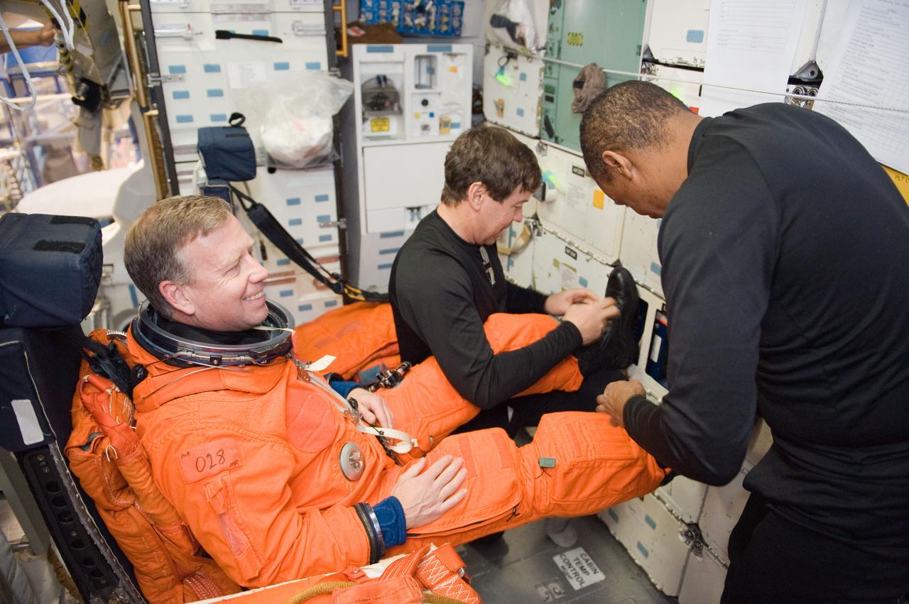 JSC2010-E-042101 (23 March 2010) --- NASA astronauts Steve Lindsey (left), STS-133 commander; Michael Barratt (right background) and Alvin Drew, both mission specialists, participate in a post insertion/de-orbit training session on the middeck of the crew compartment trainer (CCT-2) in the Space Vehicle Mockup Facility at NASA's Johnson Space Center.