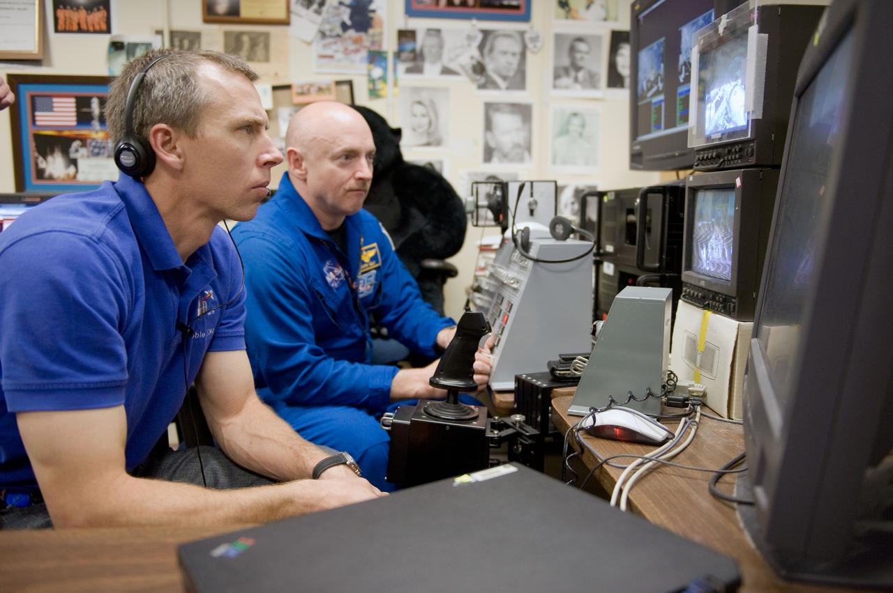 JSC2010-E-043666 (25 March 2010) --- NASA astronauts Mark Kelly (background), STS-134 commander; and Andrew Feustel, mission specialist, use the virtual reality lab in the Space Vehicle Mock-up Facility at NASA's Johnson Space Center to train for some of their duties aboard the space shuttle and space station. This type of computer interface, paired with virtual reality training hardware and software, helps to prepare crew members for dealing with space station elements.