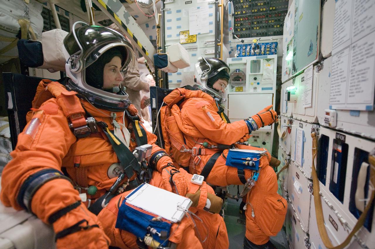 JSC2010-E-043948 (26 March 2010) --- NASA astronauts Nicole Stott and Michael Barratt, both STS-133 mission specialists, attired in training versions of their shuttle launch and entry suits, participate in a training session on the middeck of the crew compartment trainer (CCT-2) in the Space Vehicle Mockup Facility at NASA's Johnson Space Center.