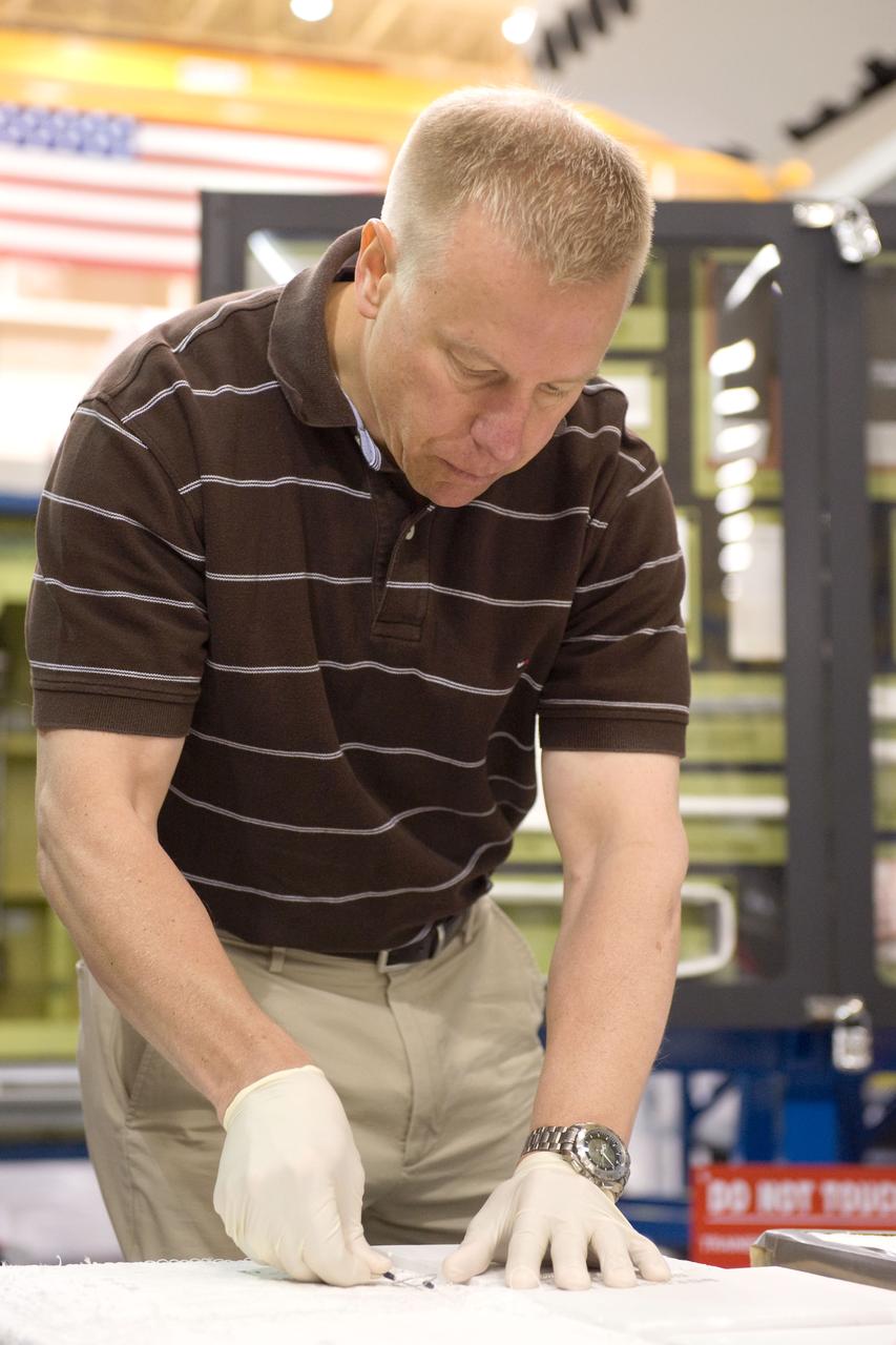 JSC2010-E-044337 (30 March 2010) --- NASA astronaut Tim Kopra, STS-133 mission specialist, participates in an EVA tile repair training session in the Space Vehicle Mockup Facility at NASA's Johnson Space Center.