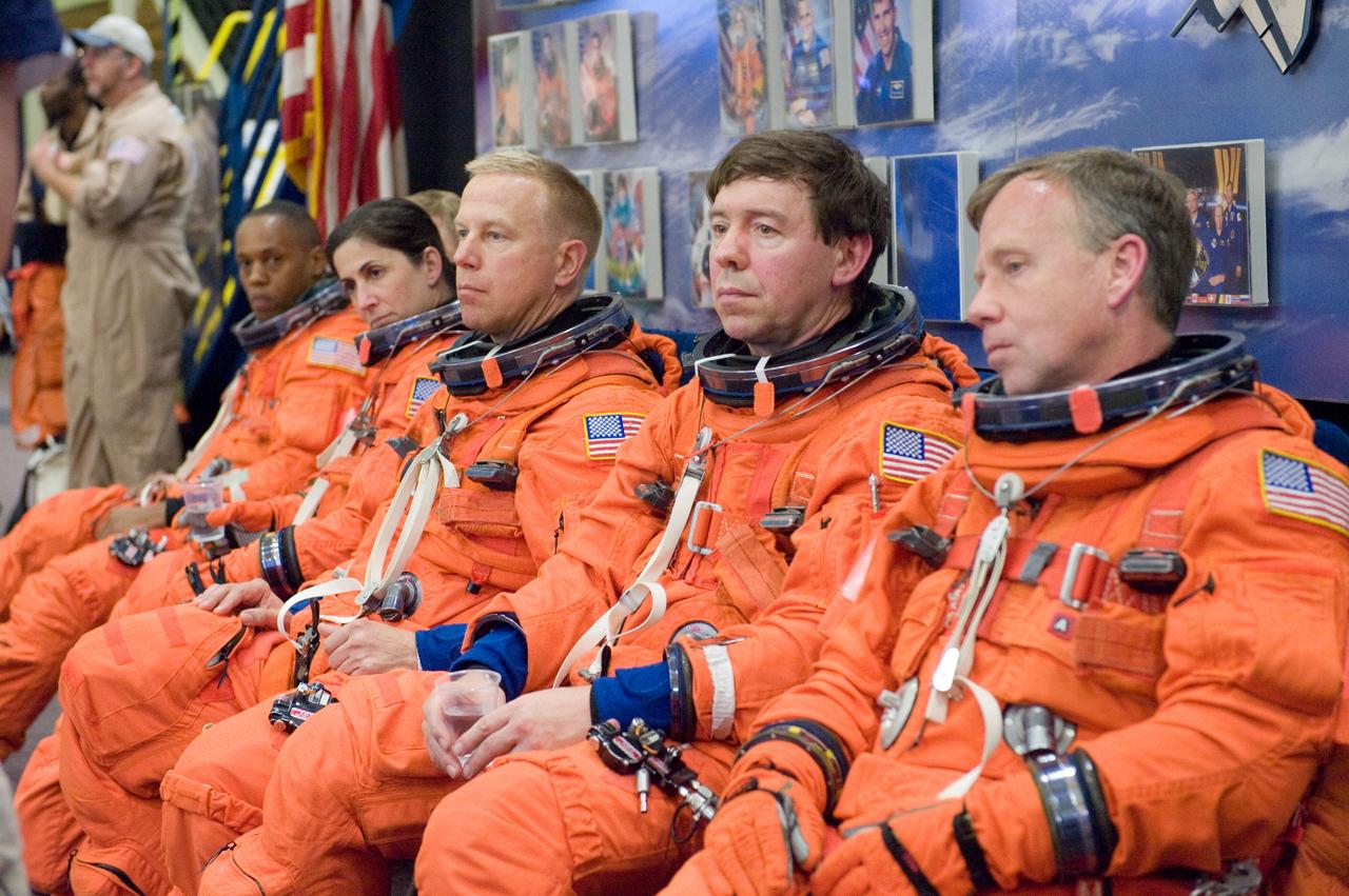 JSC2010-E-046408 (31 March 2010) --- Attired in training versions of their shuttle launch and entry suits, the STS-133 crew members await the start of a Full Fuselage Trainer (FFT) mock-up training session in the Space Vehicle Mockup Facility at NASA's Johnson Space Center. Pictured from the right are NASA astronauts Steve Lindsey, commander; Michael Barratt, Tim Kopra, Nicole Stott, all mission specialists; Eric Boe (mostly obscured), pilot; and Alvin Drew, mission specialist.