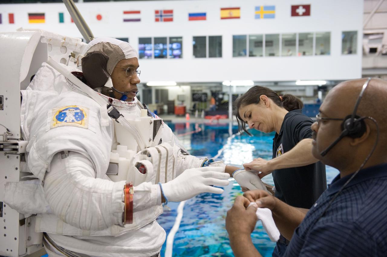 JSC2010-E-046452 (31 March 2010) --- NASA astronaut Alvin Drew, STS-133 mission specialist, dons a training version of his Extravehicular Mobility Unit (EMU) spacesuit in preparation for a spacewalk training session in the waters of the Neutral Buoyancy Laboratory (NBL) near NASA's Johnson Space Center. NASA astronaut Nicole Stott, mission specialist, assisted Drew.