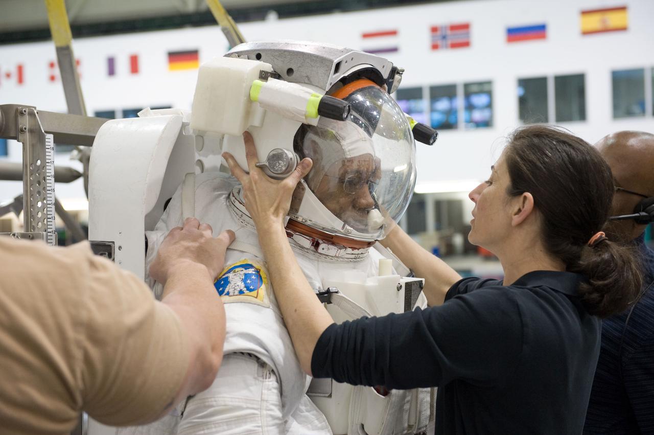 JSC2010-E-046454 (31 March 2010) --- NASA astronaut Alvin Drew, STS-133 mission specialist, dons a training version of his Extravehicular Mobility Unit (EMU) spacesuit in preparation for a spacewalk training session in the waters of the Neutral Buoyancy Laboratory (NBL) near NASA's Johnson Space Center. NASA astronaut Nicole Stott, mission specialist, assisted Drew.