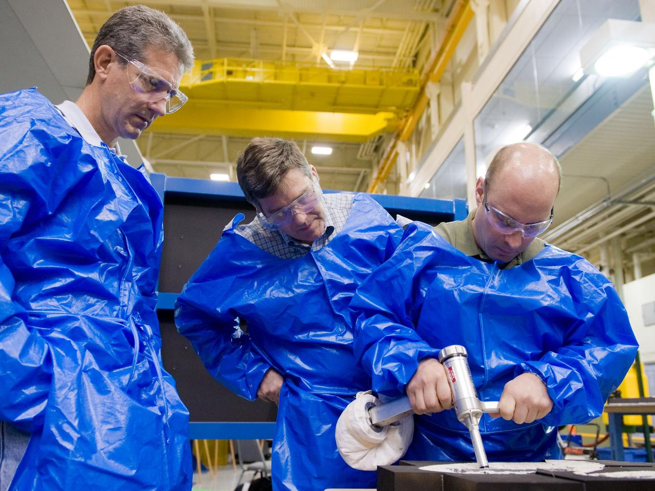 JSC2010-E-046472 (2 April 2010) --- NASA astronauts Garrett Reisman (right), Steve Bowen (center) and Michael Good, all STS-132 mission specialists, participate in an EVA tile repair training session in the Space Vehicle Mockup Facility at NASA's Johnson Space Center.
