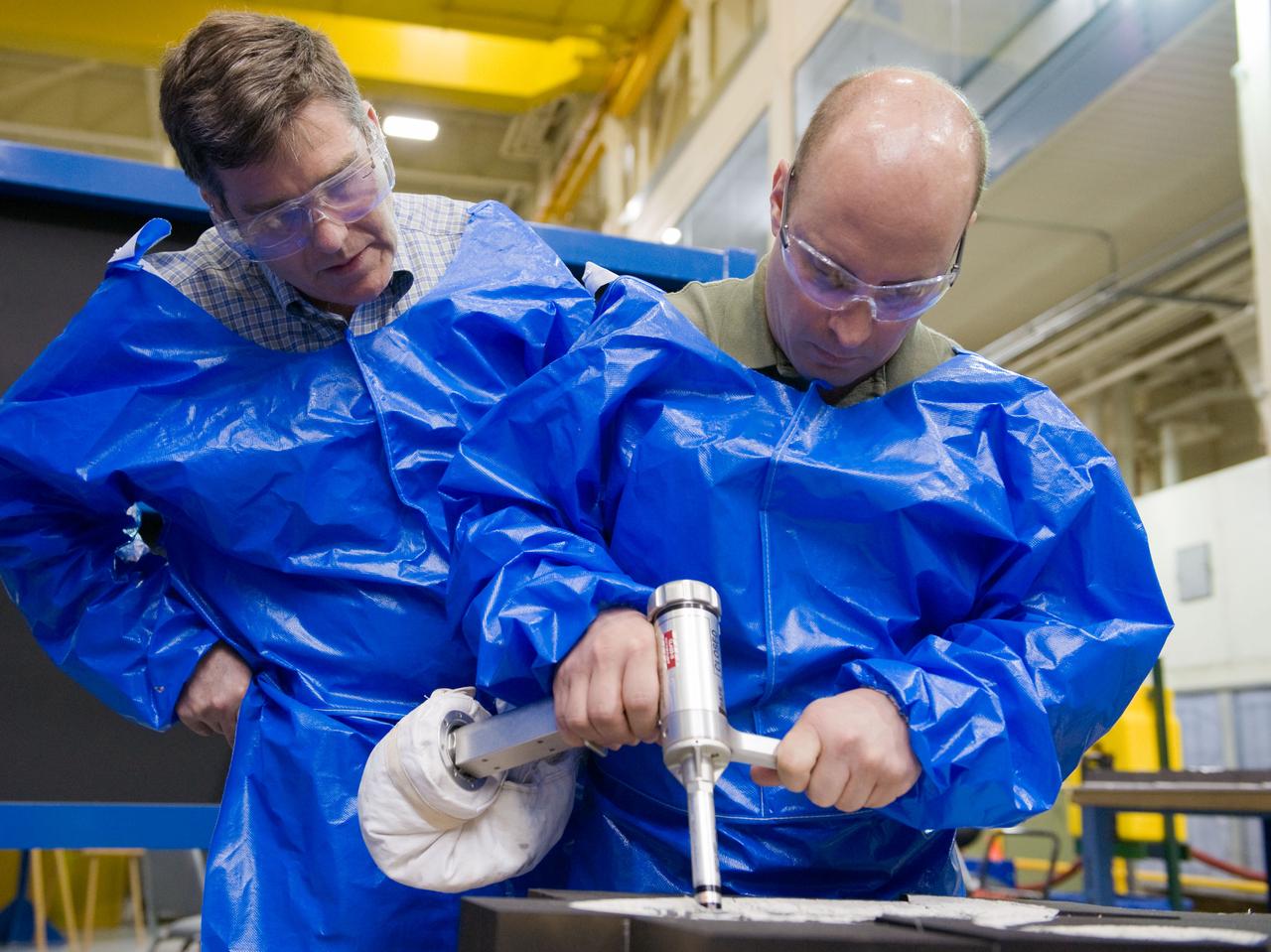 JSC2010-E-046473 (2 April 2010) --- NASA astronauts Garrett Reisman (right) and Steve Bowen, both STS-132 mission specialists, participate in an EVA tile repair training session in the Space Vehicle Mockup Facility at NASA's Johnson Space Center.