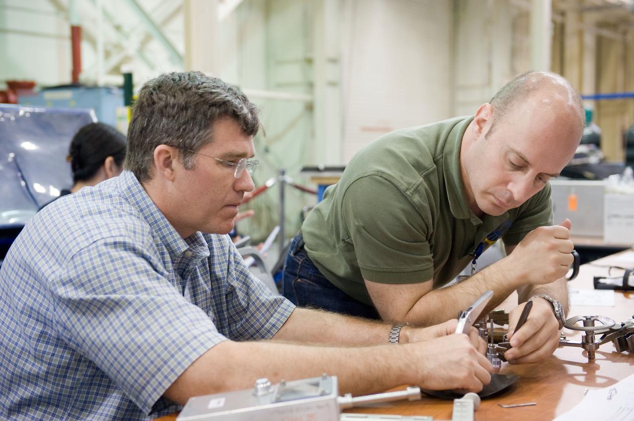JSC2010-E-046479 (2 April 2010) --- NASA astronauts Steve Bowen (left) and Garrett Reisman, both STS-132 mission specialists, participate in an EVA tile repair training session in the Space Vehicle Mockup Facility at NASA's Johnson Space Center.