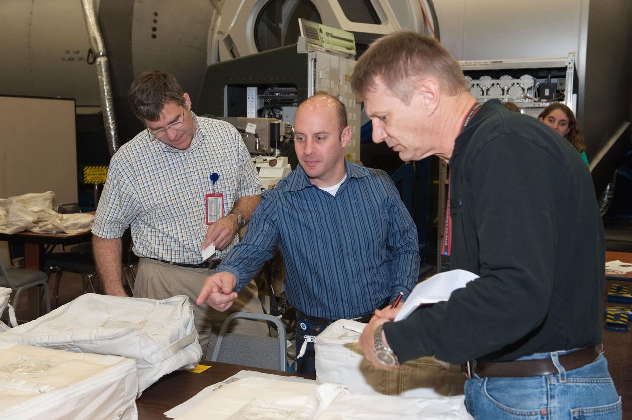 JSC2010-E-049147 (1 April 2010) --- NASA astronauts Steve Bowen (left), Garrett Reisman and Piers Sellers, all STS-132 mission specialists, participate in a practice session of transferring items aboard the International Space Station in the Space Vehicle Mock-up Facility at NASA's Johnson Space Center.