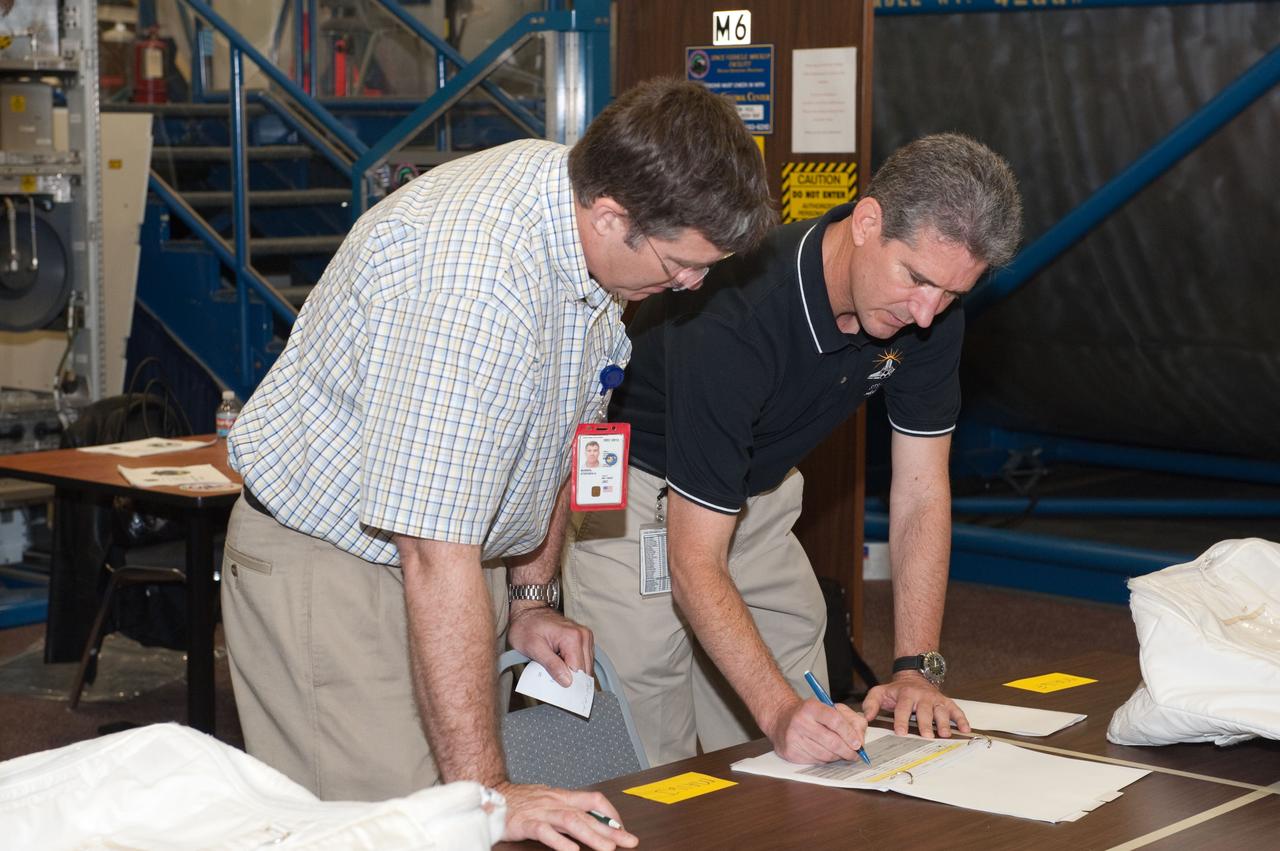 JSC2010-E-049148 (1 April 2010) --- NASA astronauts Steve Bowen (left) and Michael Good, both STS-132 mission specialists, participate in a practice session of transferring items aboard the International Space Station in the Space Vehicle Mock-up Facility at NASA's Johnson Space Center.