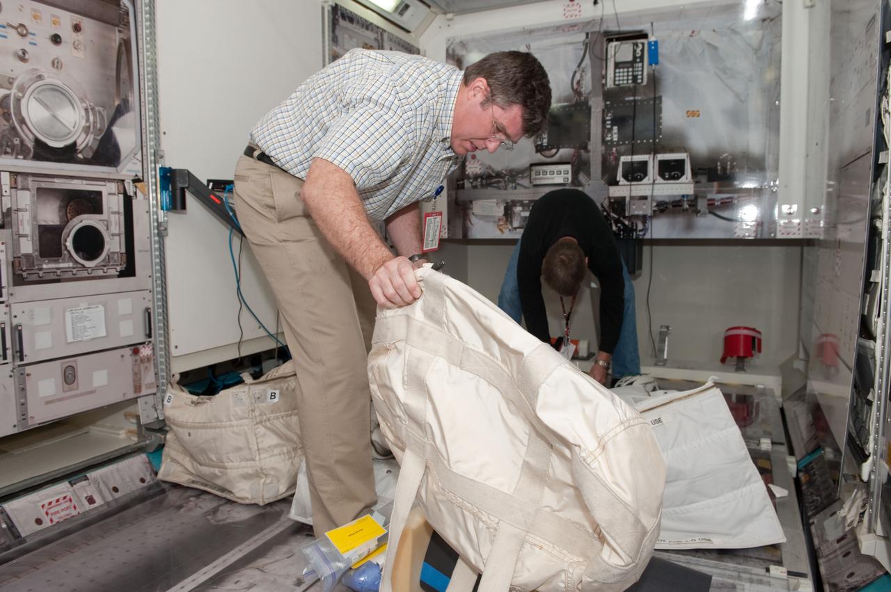 JSC2010-E-049154 (1 April 2010) --- NASA astronaut Steve Bowen, STS-132 mission specialist, participates in a practice session of transferring items aboard the International Space Station in an ISS mock-up/trainer in the Space Vehicle Mock-up Facility at NASA's Johnson Space Center.