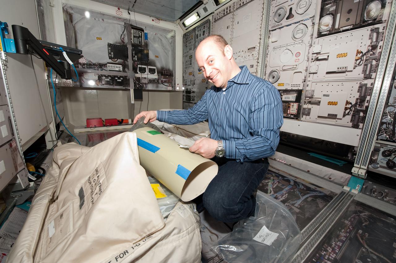 JSC2010-E-049157 (1 April 2010) --- NASA astronaut Garrett Reisman, STS-132 mission specialist, participates in a practice session of transferring items aboard the International Space Station in an ISS mock-up/trainer in the Space Vehicle Mock-up Facility at NASA's Johnson Space Center.