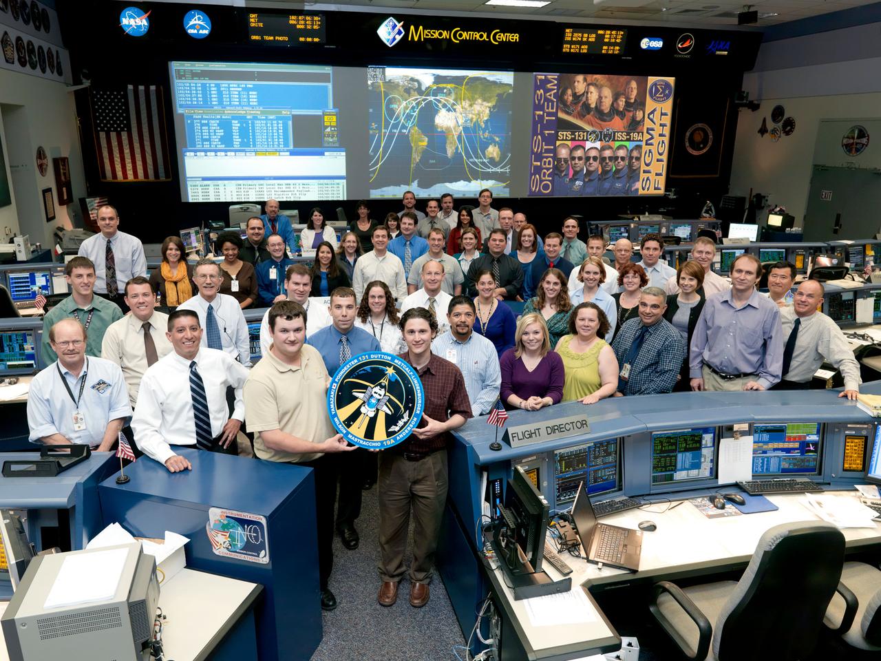 JSC2010-E-050680 (12 April 2010) --- The members of the STS-131 Orbit 1 flight control team pose for a group portrait in the space shuttle flight control room in the Mission Control Center at NASA's Johnson Space Center. Flight director Richard Jones (second left) is on the front row.