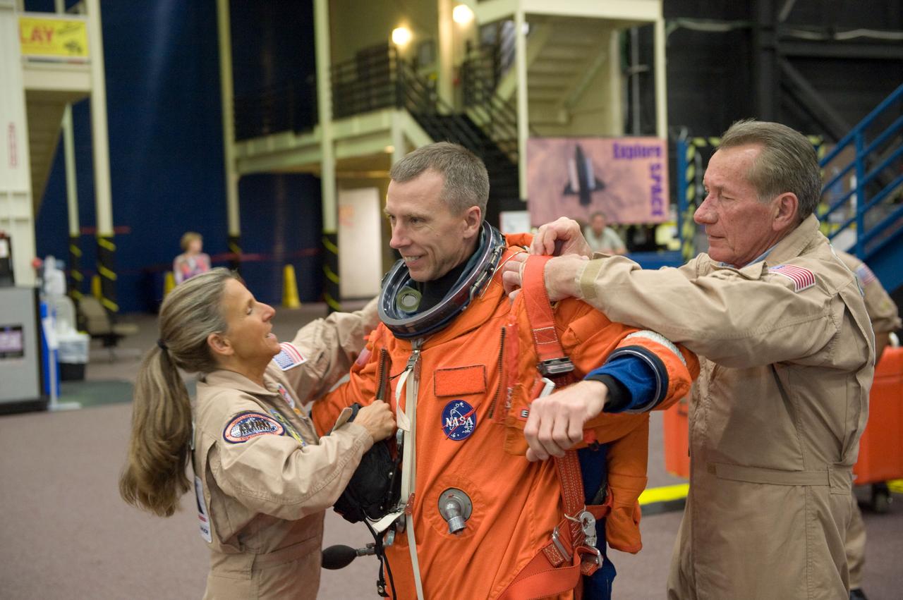 JSC2010-E-051959 (12 April 2010) --- NASA astronaut Andrew Feustel, STS-134 mission specialist, dons a training version of his shuttle launch and entry suit in preparation for a post insertion/de-orbit training session in the Space Vehicle Mock-up Facility at NASA's Johnson Space Center. United Space Alliance suit technicians Toni Cost-Davis and Jim Cheatham assisted Feustel.