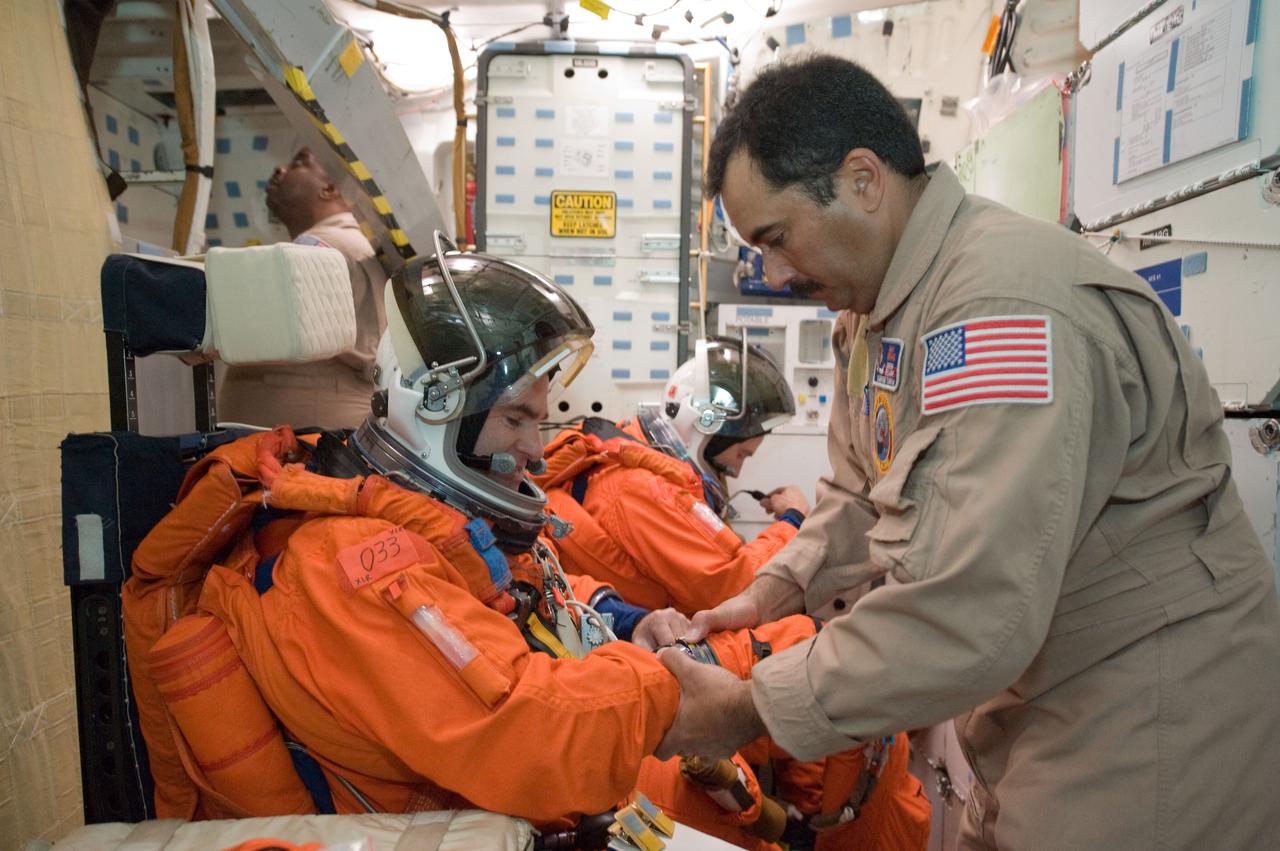 JSC2010-E-051962 (12 April 2010) --- NASA astronauts Greg Chamitoff (foreground) and Andrew Feustel, both STS-134 mission specialists, attired in training versions of their shuttle launch and entry suits, participate in a post insertion/de-orbit training session on the middeck of a Full Fuselage Trainer (FFT) mock-up in the Space Vehicle Mock-up Facility at NASA's Johnson Space Center. United Space Alliance suit technician Raymond Cuevas assisted the crew members.