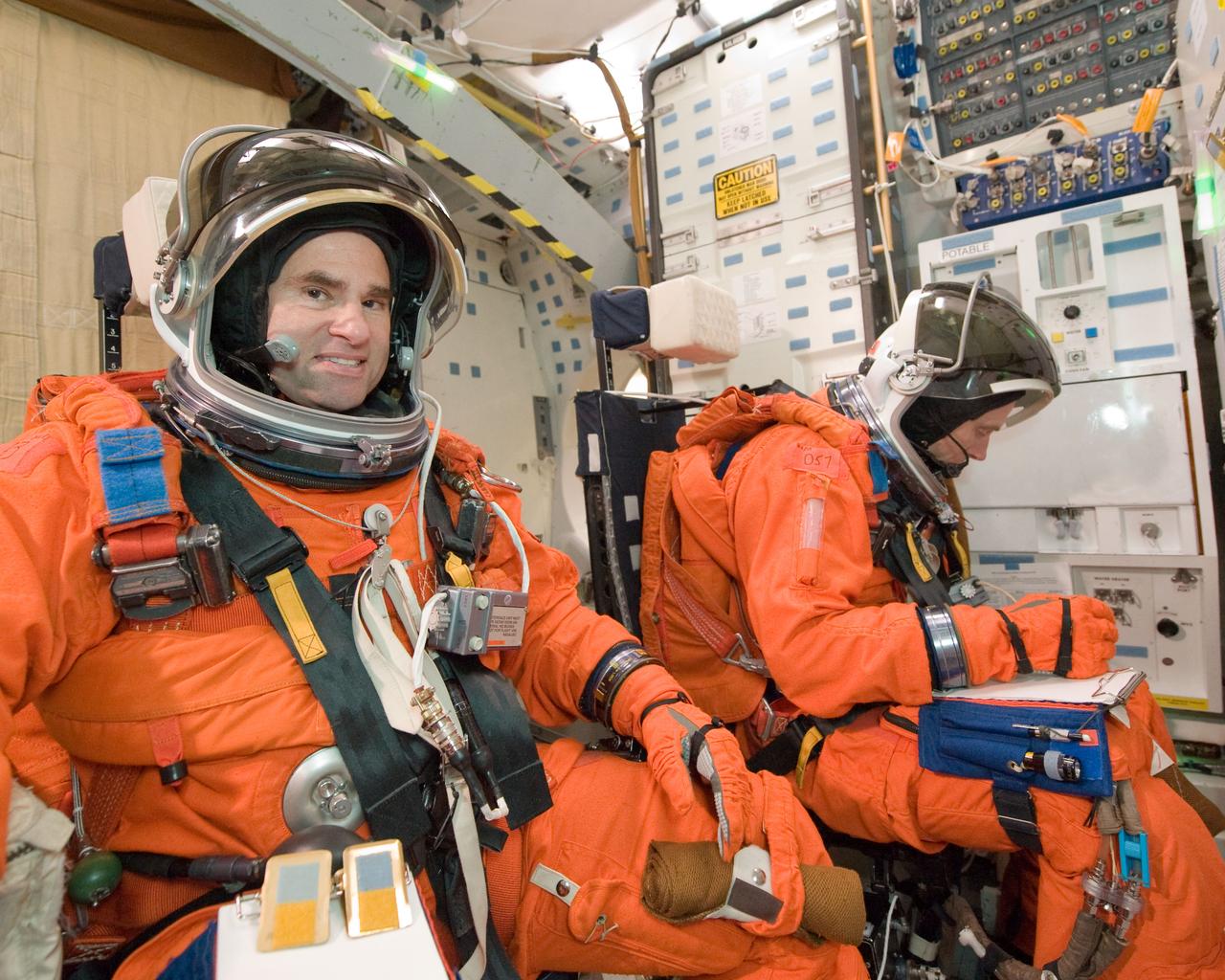 JSC2010-E-051963 (12 April 2010) --- NASA astronauts Greg Chamitoff (left) and Andrew Feustel, both STS-134 mission specialists, attired in training versions of their shuttle launch and entry suits, participate in a post insertion/de-orbit training session on the middeck of a Full Fuselage Trainer (FFT) mock-up in the Space Vehicle Mock-up Facility at NASA's Johnson Space Center.