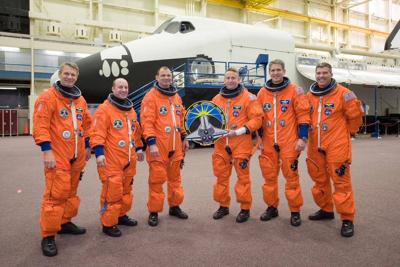 JSC2010-E-051984 (8 April 2010) --- Attired in training versions of their shuttle launch and entry suits, the STS-132 crew members take a brief break for a portrait in the Space Vehicle Mock-up Facility at NASA's Johnson Space Center. NASA astronaut Ken Ham, commander, holds the STS-132 mission logo. Also pictured (from the left) are NASA astronauts Piers Sellers, Garrett Reisman, both mission specialists; Tony Antonelli, pilot; Michael Good and Steve Bowen, both mission specialists.