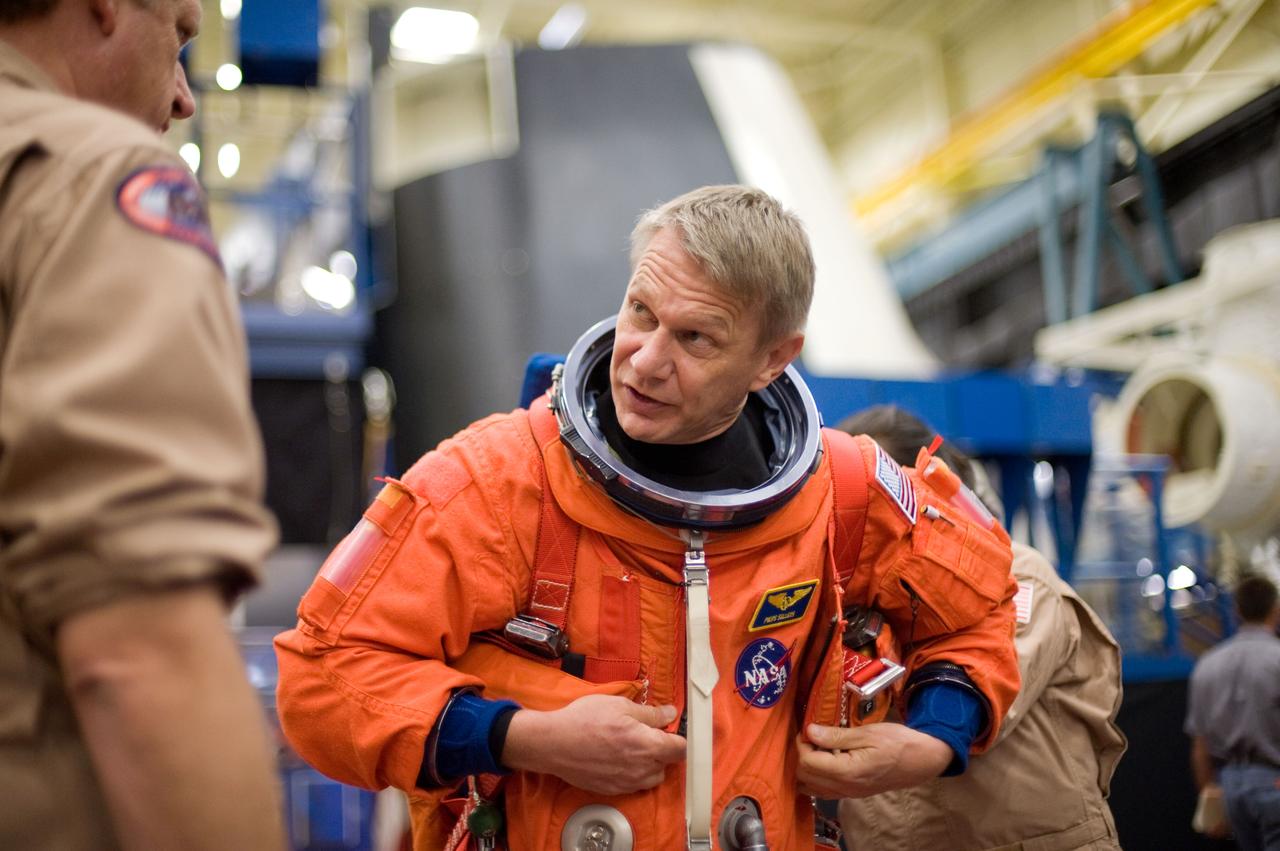JSC2010-E-051992 (8 April 2010) --- NASA astronaut Piers Sellers, STS-132 mission specialist, dons a training version of his shuttle launch and entry suit in preparation for an ingress/egress training session in the Space Vehicle Mock-up Facility at NASA's Johnson Space Center.