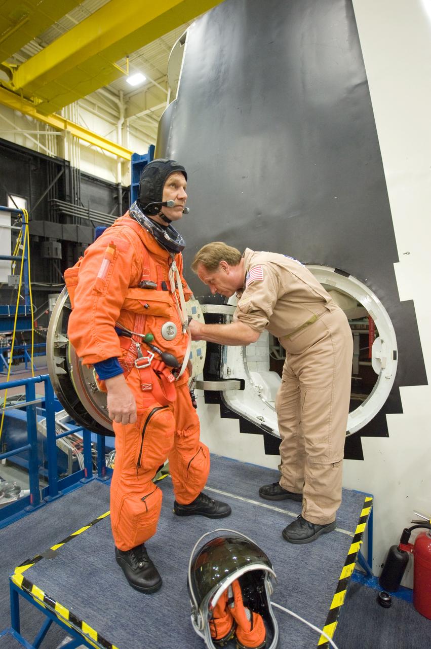 JSC2010-E-052003 (8 April 2010) --- NASA astronaut Piers Sellers, STS-132 mission specialist, attired in a training version of his shuttle launch and entry suit, participates in an ingress/egress training session in the Space Vehicle Mock-up Facility at NASA's Johnson Space Center. United Space Alliance suit technician John Hazelhurst assisted Sellers.